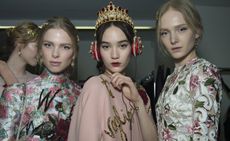 Models wearing colorful dresses with floral patterns and golden hairpiece elements, from Dolce & Gabbana A/W 2015 collection.