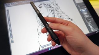 A close up of an artist holding the X3 stylus against the XPPEN drawing tablet