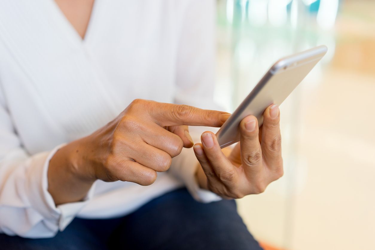 A woman holds a smartphone.