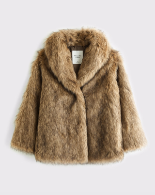 a fur coat from Abercrombie & Fitch in front of a plain backdrop