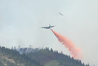 A U.S. Forest Service aircraft breaks away, top, as a Modular Airborne Firefighting System-equipped C-130 aircraft begins dropping flame retardant on a section of the Waldo Canyon fire near Colorado Springs, Colo., on June 26, 2012.