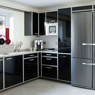 kitchen with black cabinets and silver refrigerator