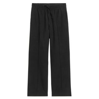 arket black wool trousers flat lay