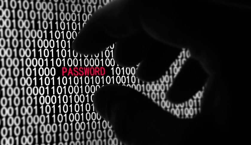 A shadowy hand reaches for the word &#039;PASSWORD&#039; displayed on a computer screen.