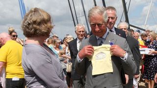 King Charles most memorable moments - Prince Charles at the 2013 Whitstable Oyster Festival, picking up a tshirt for Prince George