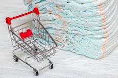 tiny shopping card beside large pile of diapers