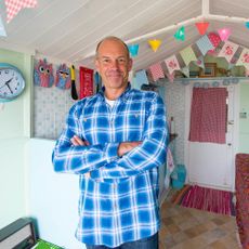phil spencer with bunting flag and clock on wall