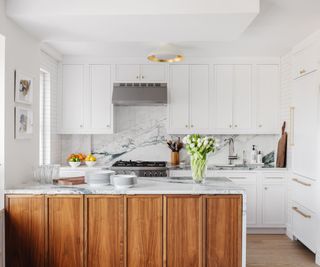 kitchen with dark wood cabinetry white cupboards marble countertops white walls