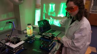 A new tool can project a 3D image into a jar of liquid solvent. Here, Cecilia O'Brien, a summer intern with the Lippert lab group, works with the technology.