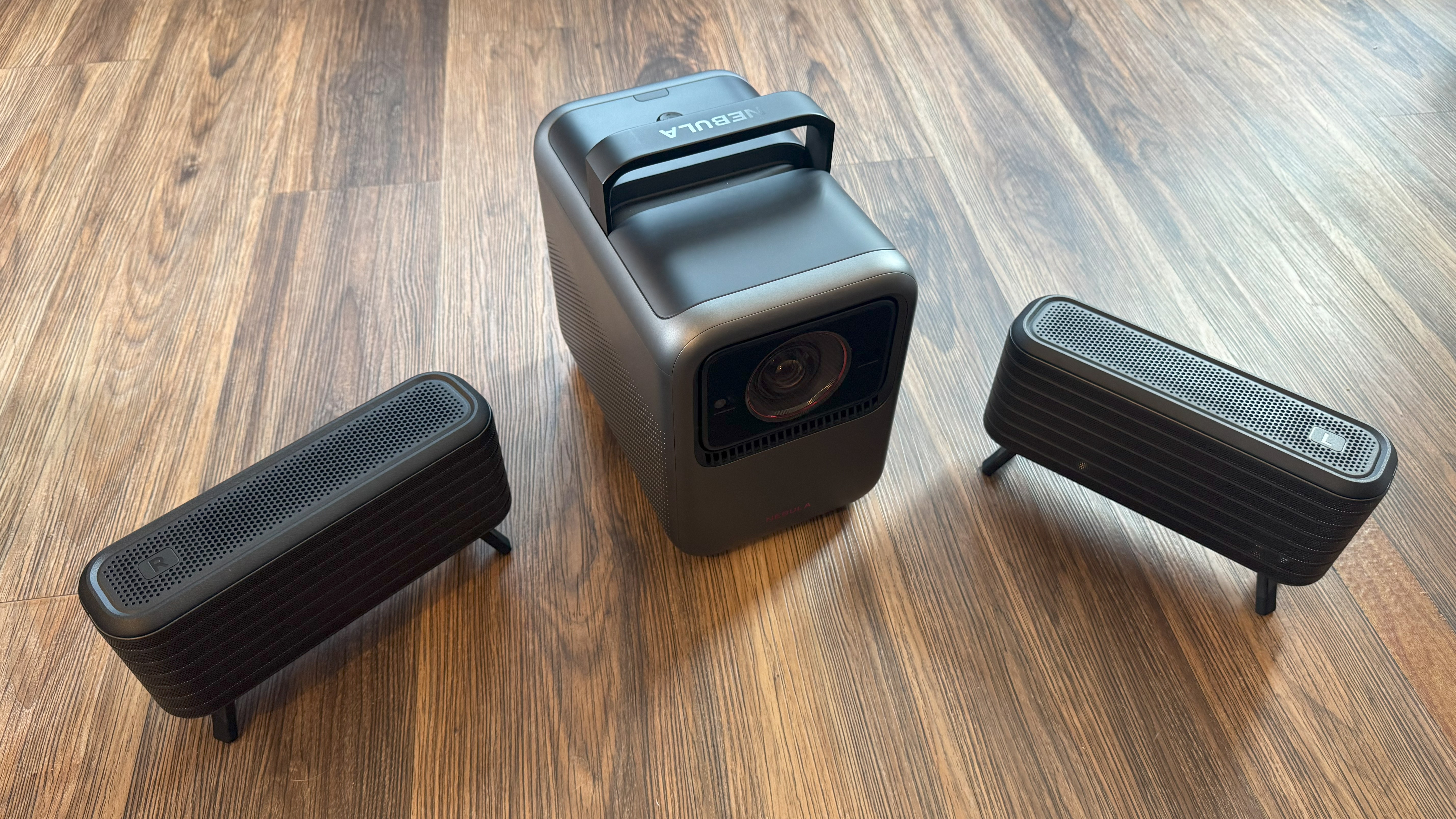 Anker Nebula X1 on floor with speakers