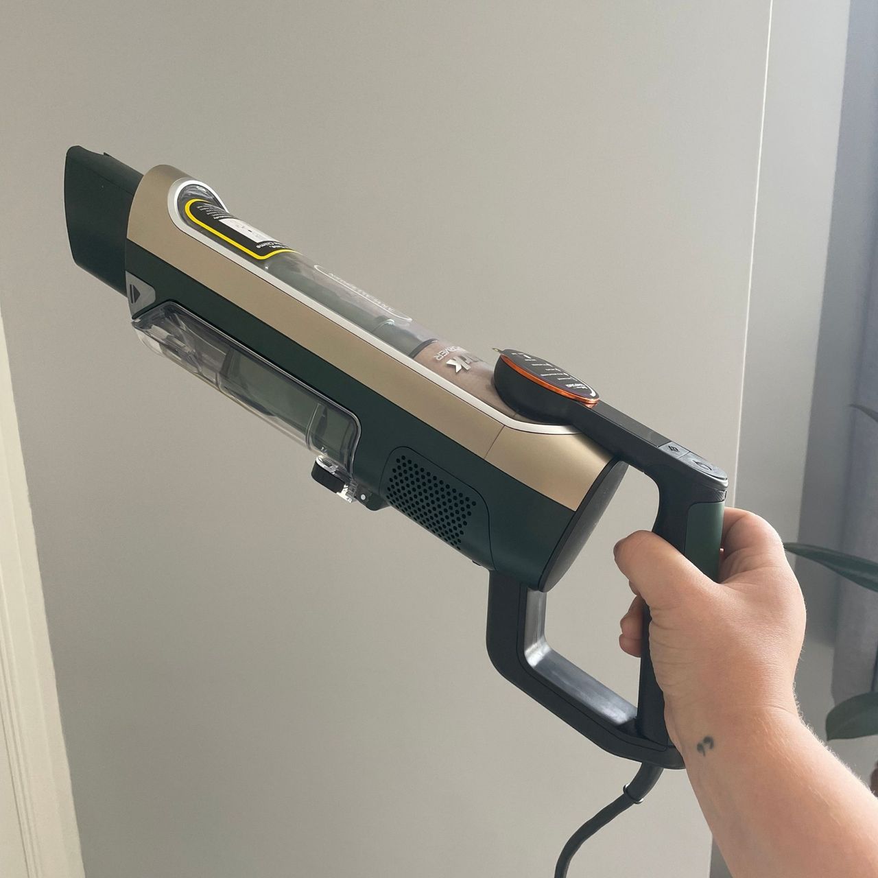 Hand holding up the handheld section of the Shark PowerDetect Transformer Corded Upright Vacuum Cleaner