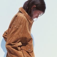 A Zara model wearing a brown suede leather bomber jacket.