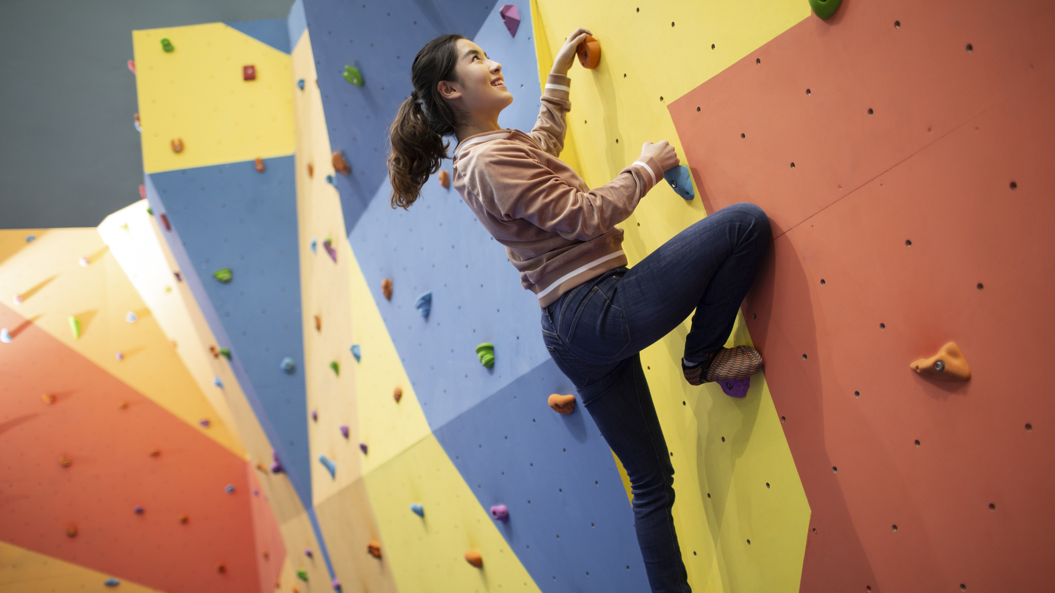 Woman climbing on indoor bouldering wall
