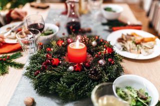 A Christmas table with a wreath around a candle