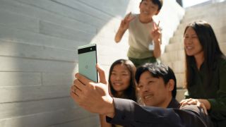 A family of four including father, mother, daughter and son taking a selfie using the Google Pixel 6a