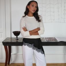 Woman in white sweater, jeans and brown lace dress