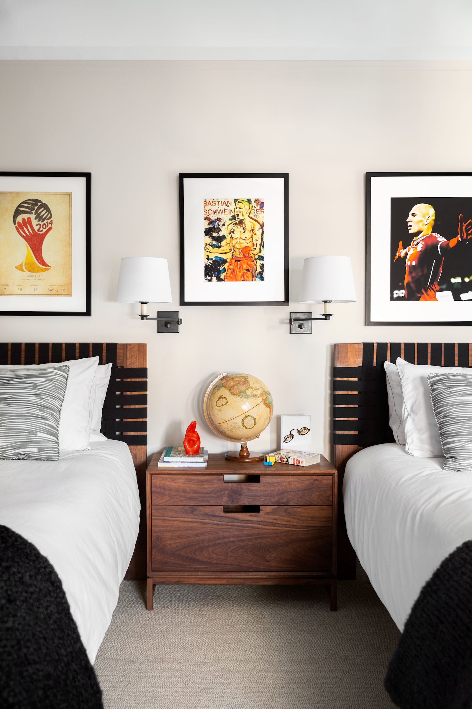 Shared teen's bedroom with matching beds and artwork hanging above