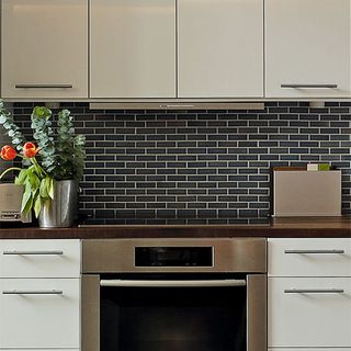 kitchen with black tiles wall and kitchen cabinets