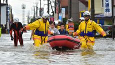 Rescue workers transport people in a rubber boat in Oyama in Tochigi prefecture, north of Tokyo on Sept. 10, 2015, just after torrential rains flooded rivers and triggered landslides.