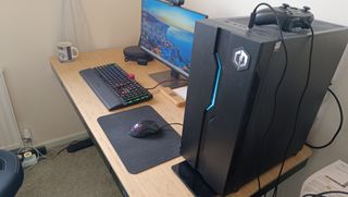 A light-brown FlexiSpot Comhar Pro Q8 standing desk with computer equipment on top of it.