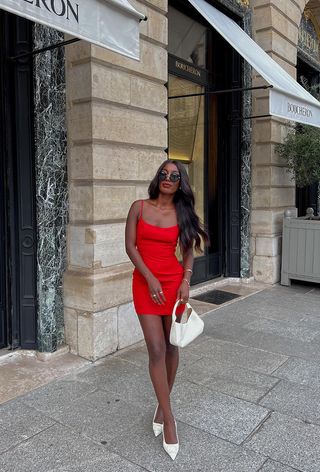 a photo of a woman wearing a red mini dress with white kitten heel pumps