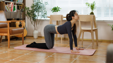 woman in cat cow pose on yoga mat 