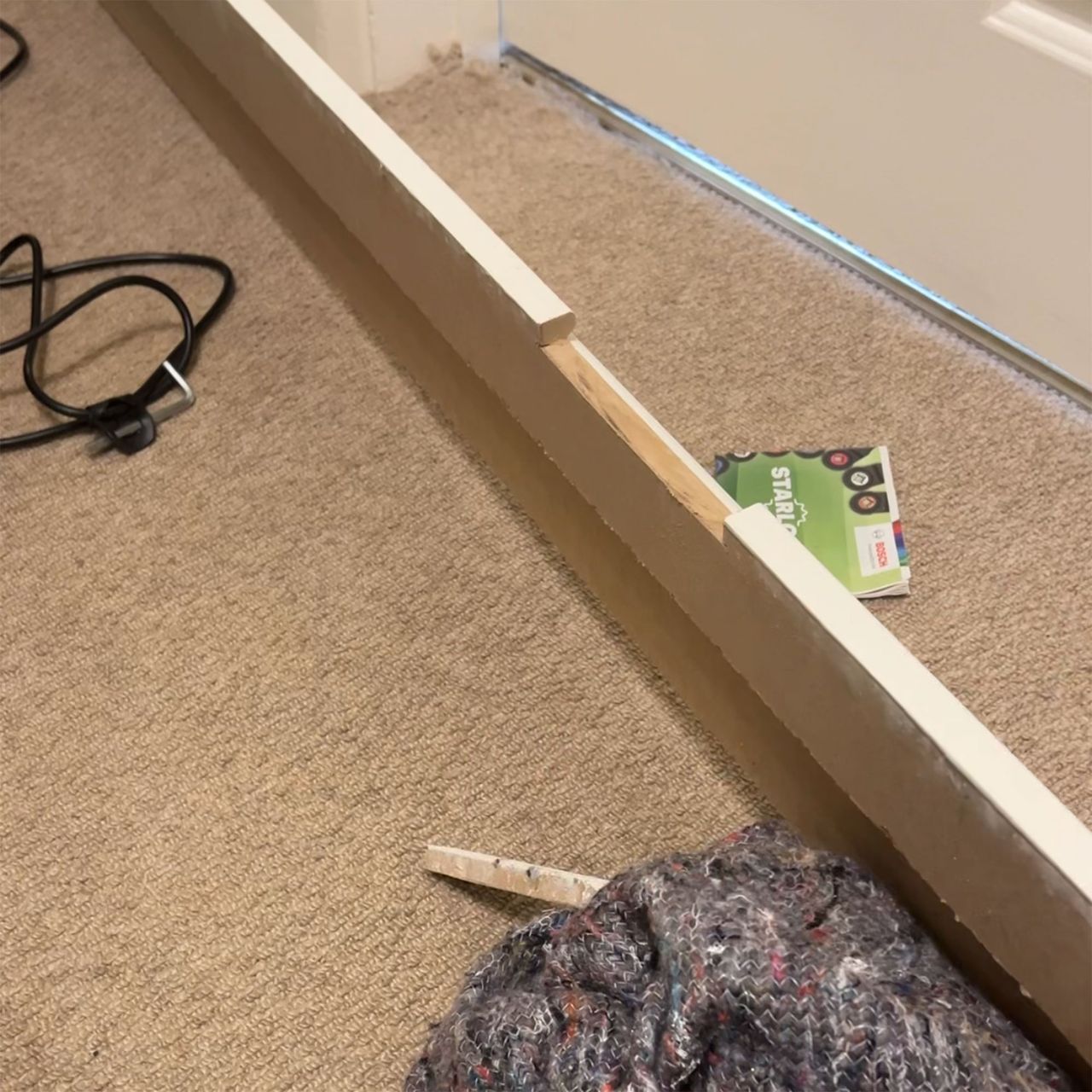 Skirting board cover on beige carpet before installation