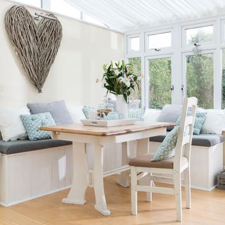 room with white wall wooden table and cushions