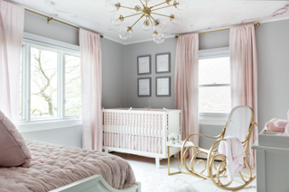 A bedroom with grey walls and pink furnishings