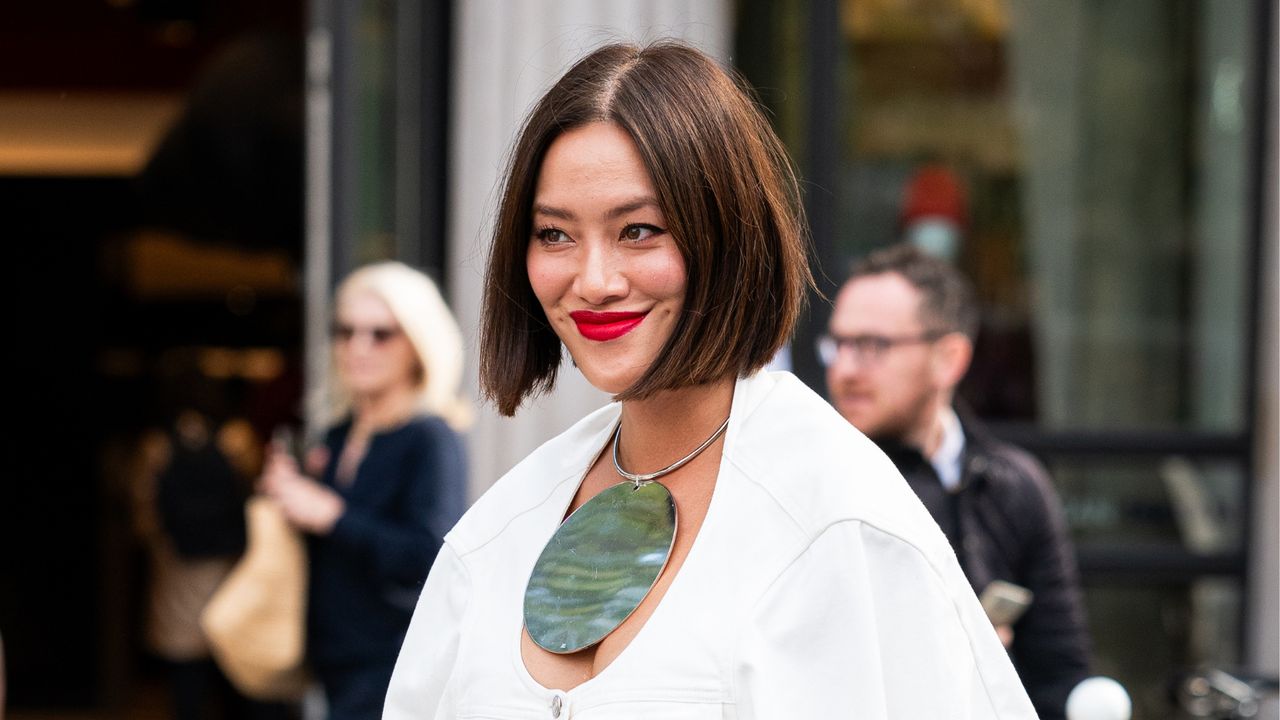 Tiffany Hsu wears a cream denim jacket with matching maxi skirt, black bag and big round necklace, outside The Row, during the Womenswear Spring/Summer 2024 as part of Paris Fashion Week on September 27, 2023 in Paris, France