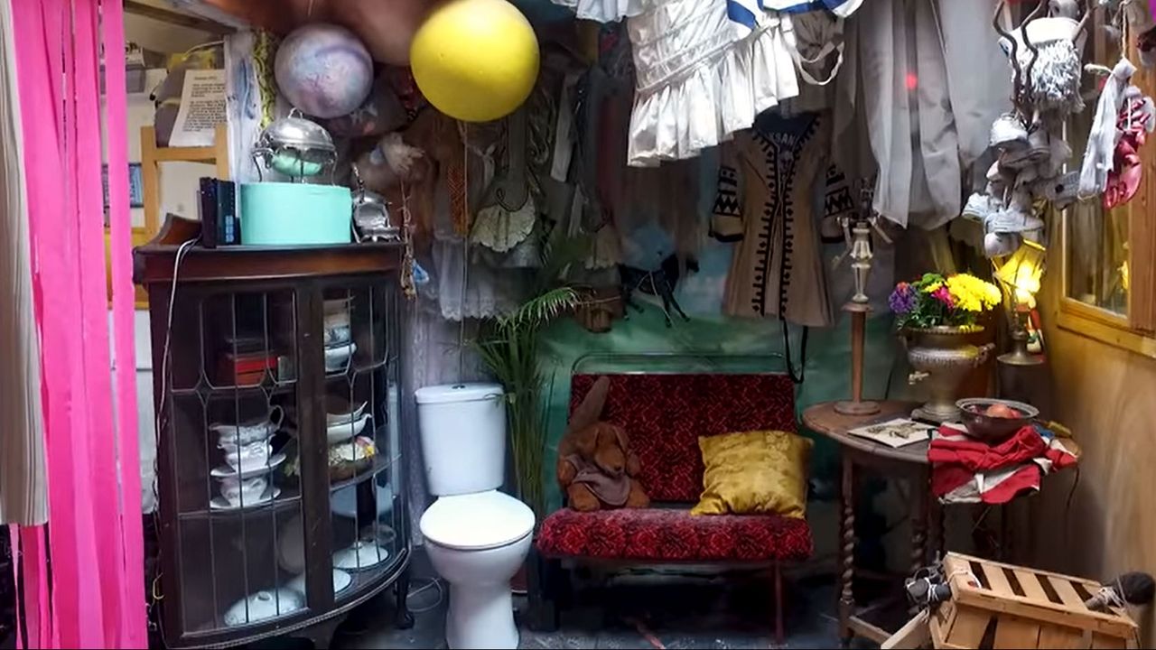 london room with toilet and clothes on walls