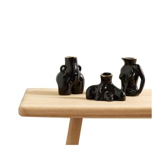 three women shaped vases in black on wooden bench