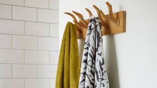 picture of two towels hung up on a wooden hook rack