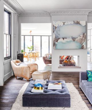Open plan room with white walls, wood floor and pastel furniture