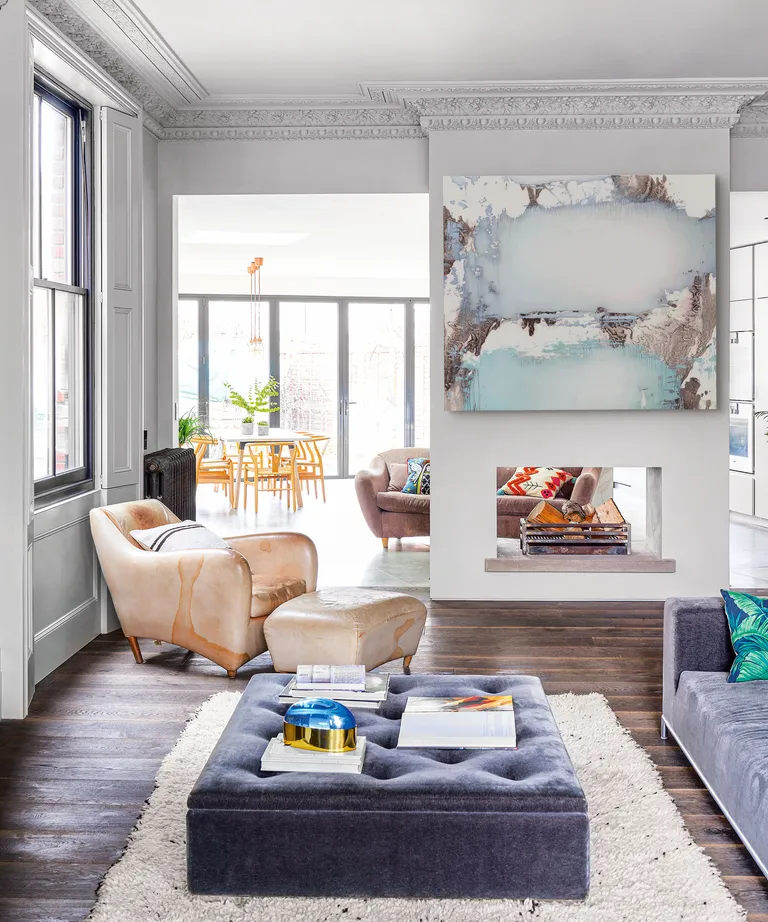 Open plan room with white walls, wood floor and pastel furniture