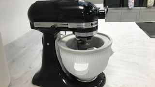 kitchenaid ice cream maker in position on a black stand mixer