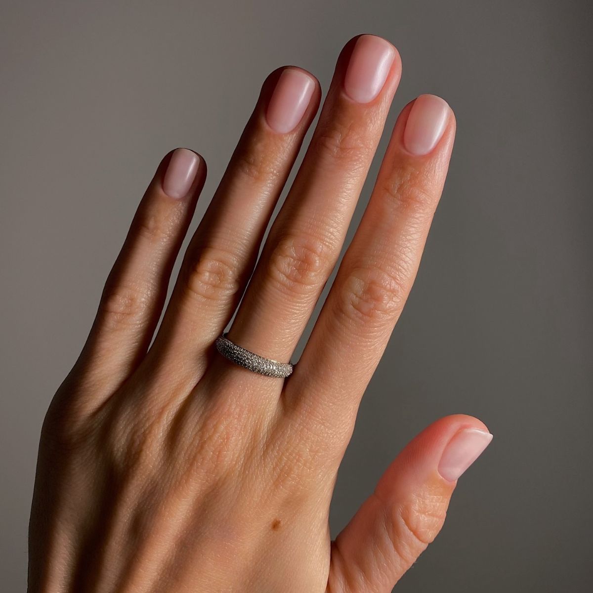 A picture of a short, powder pink, matte manicure