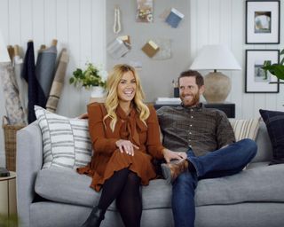 Syd and Shea McGee sat on gray sofa in Dream Home Makeover