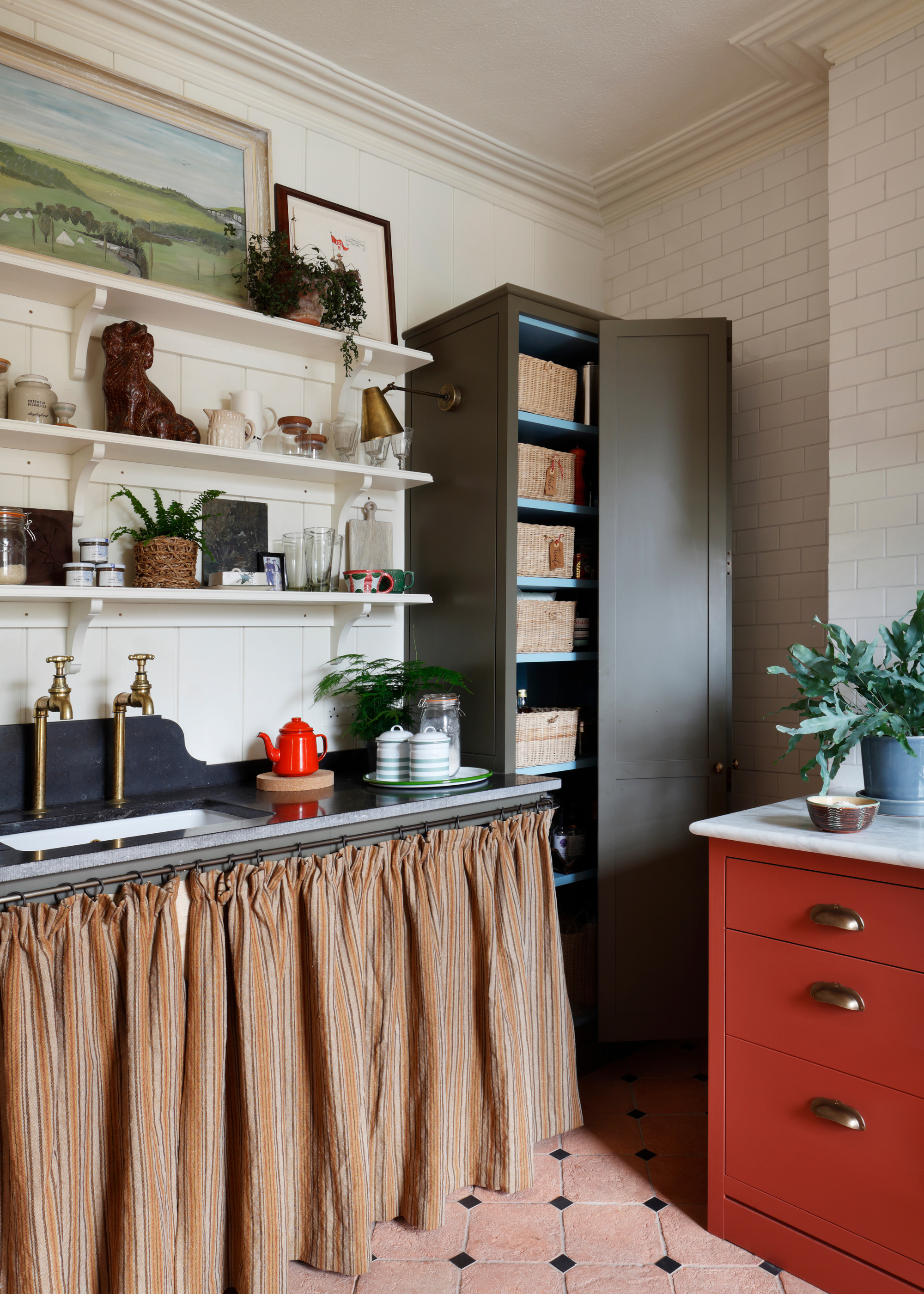 A colourful but subtle traditional kitchen with lots of soft textures like the cutain to cover the units, and open shelving