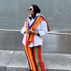 Yusra Siddiqui wearing a striped sweater around her shoulders and a matching skirt, both from Christopher John Rogers' collection with J.Crew.