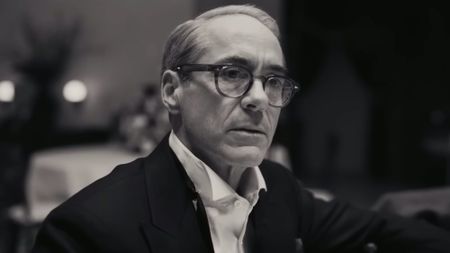 Lewiss Strauss (Robert Downey Jr.) addresses his colleagues during a meeting in Oppenheimer.