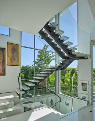 A floating corner staircase against a large window