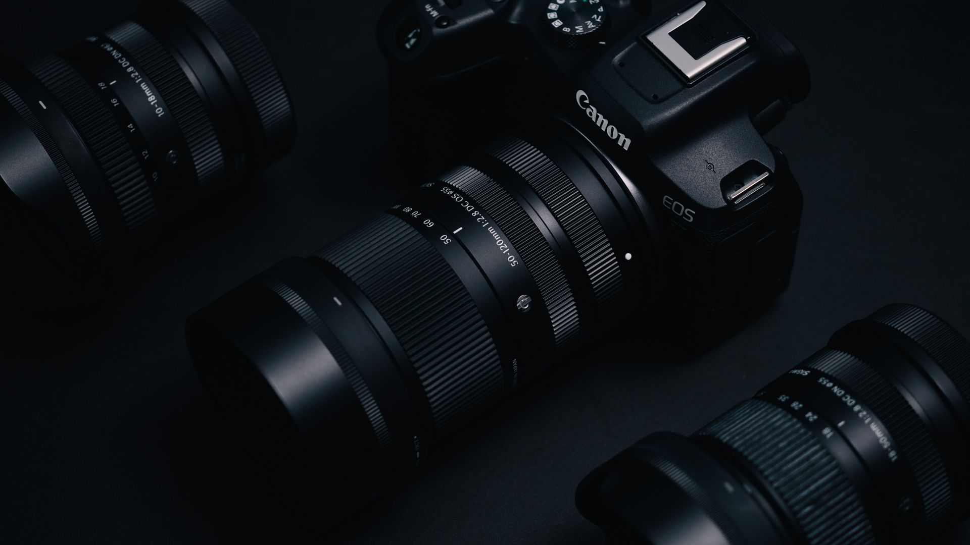 Sigma 50-120mm F2.8 DC OS Contemporary lens attached to a Canon EOS R7, in a lowkey lit studio with dark background