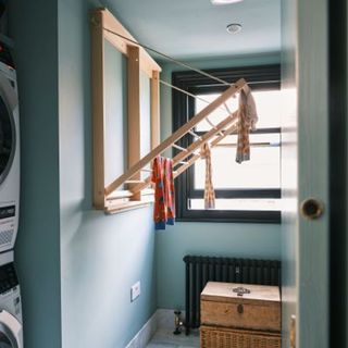 clothes hanging from laundry rack in a blue room