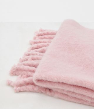 A close up of a pink fringed mohair blanket