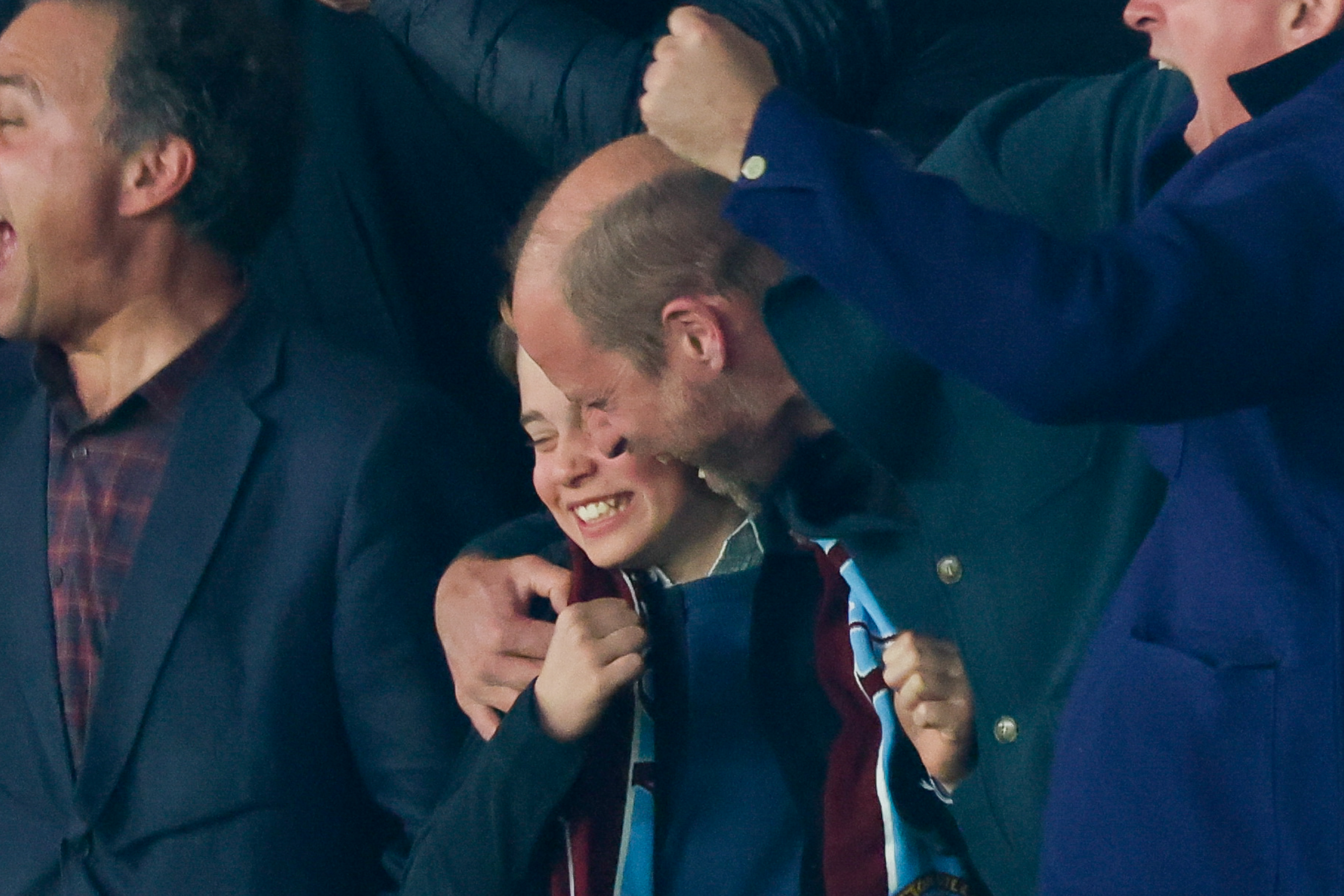 Prince George hugging Prince William at an Aston Villa game