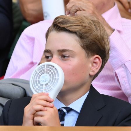Prince George using a battery operated fan