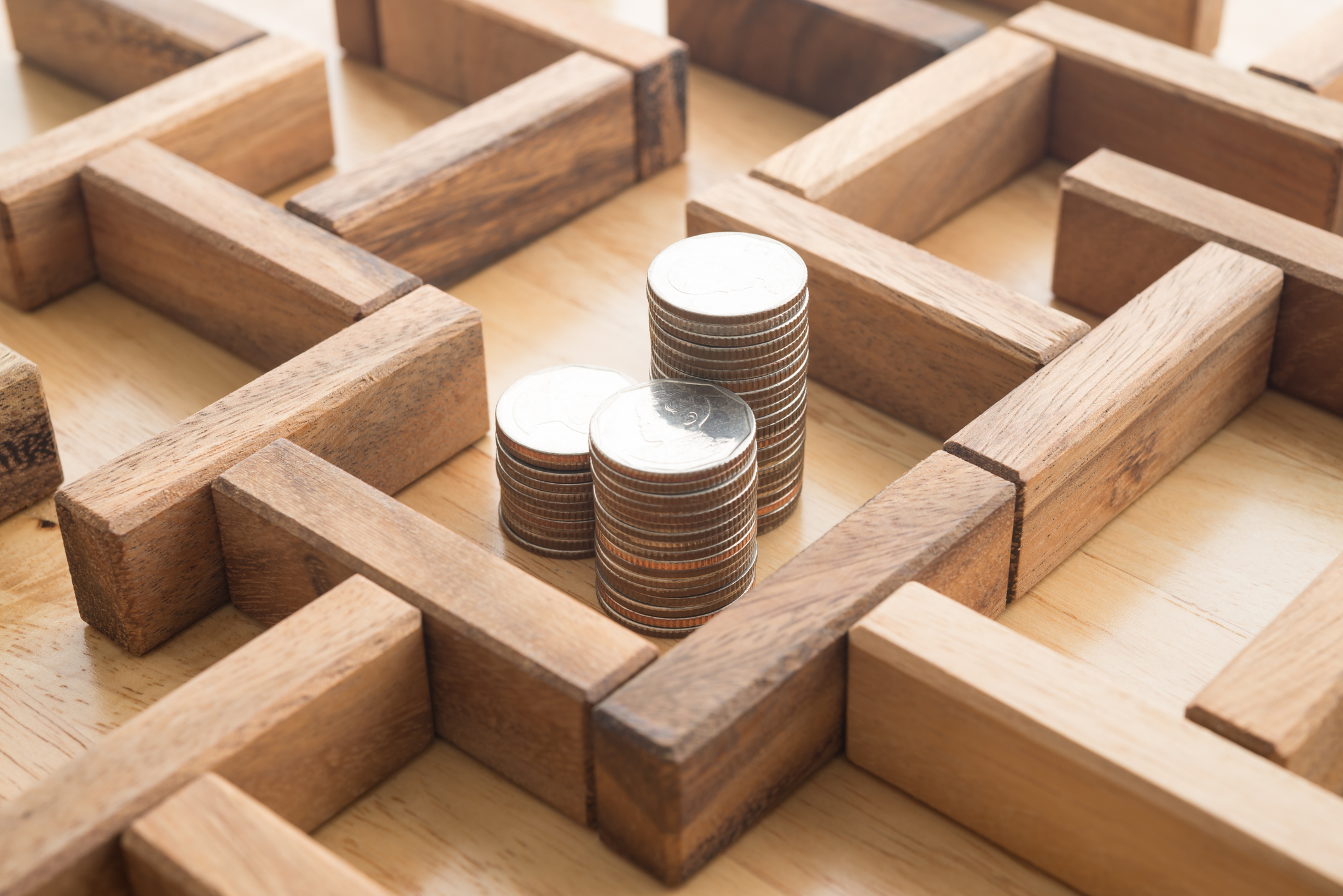 coins in the middle of a wooden maze