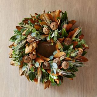 Dried Magnolia Wreath against a wooden wall.