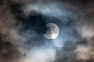 partial eclipse behind clouds